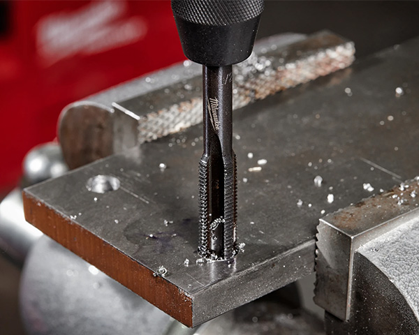 Milwaukee Tool Hand Tap Being Used to Cut Threads in Metal Closeup
